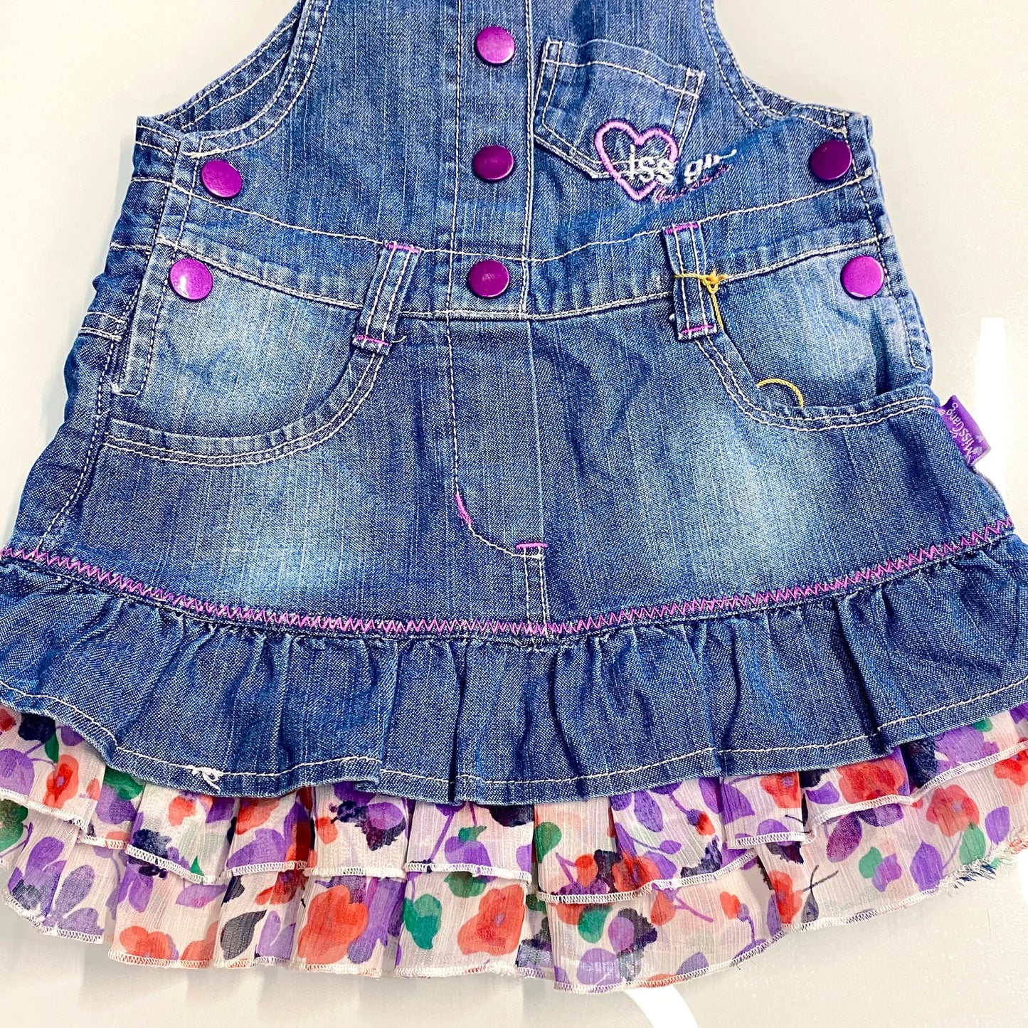 Salopette in jeans con balze floreali