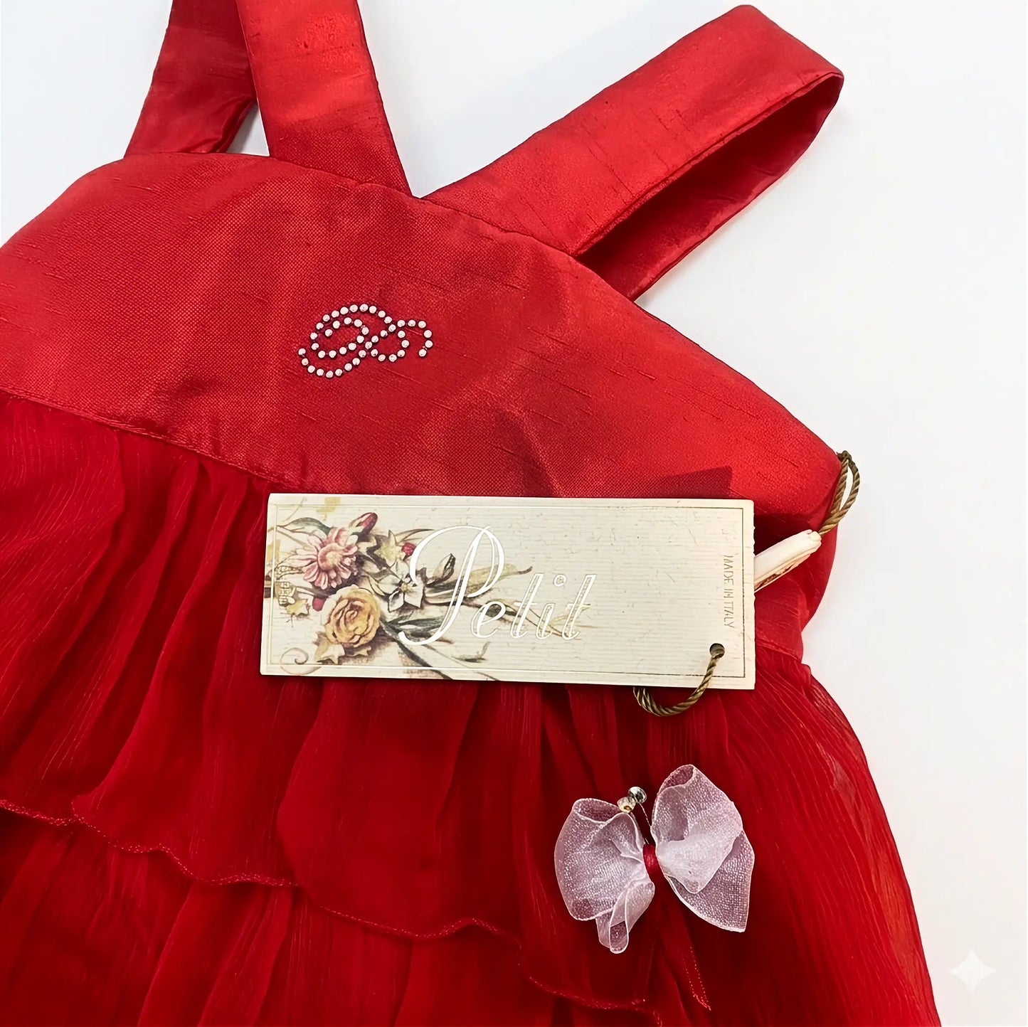 dettaglio logo strass e cartellino abito elegante da bambina rosso estivo